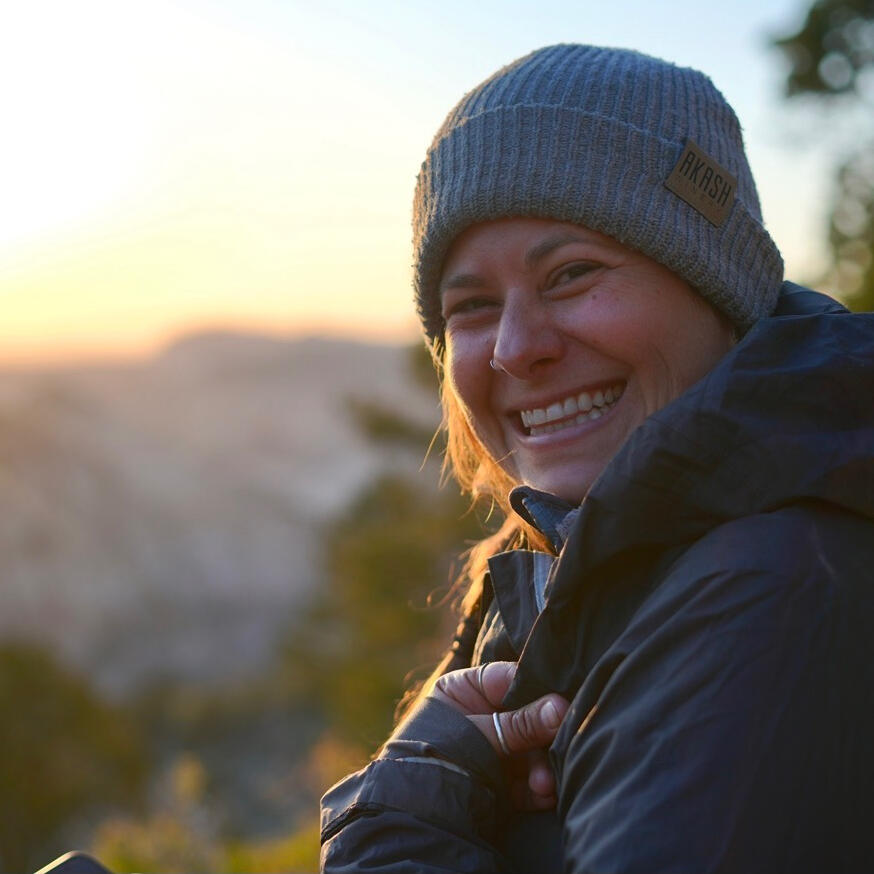 Untitled Woman in a grey beanie smiling outdoors near Flagstaff pines